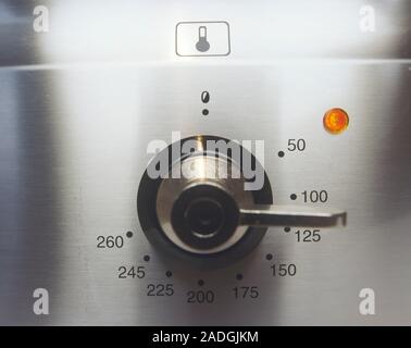 Electric oven temperature dial. The dial ranges from 0-260 degrees Celsius. Electricity is used to heat the air inside the oven. Stock Photo