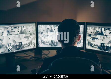 Rear back behind view of his he professional expert supervising remote panel using safety system technology equipment night shift company safety Stock Photo