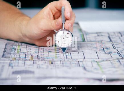 Map wheel. Engineer using a map wheel to measure distance on a plan. Stock Photo