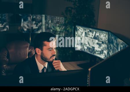 Portrait of his he nice attractive serious focused man watching television cam supervising staff preventing theft using panel at workplace workstation Stock Photo