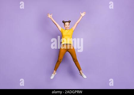 Full length body size photo of cheerful funny beautiful positive attractive girl jumping up pretending to be star wearing brown pants trousers yellow Stock Photo