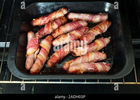 Cooked pigs in blankets, a traditional English Christmas food of sausages wrapped in bacon