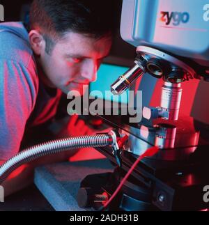 Interference microscope. Technician using an interference microscope (surface profiler) to examine a microelectromech- anical system (MEMS). The surfa Stock Photo