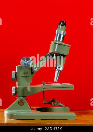 Light microscope. Side view of a light microscope with a binocular eyepiece (an eyepiece for each eye). The sample is placed on a glass slide at lower Stock Photo