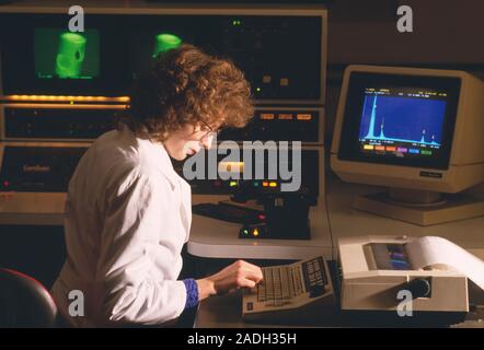 Scanning electron microscopy. Female researcher using a scanning electron microscope (SEM) for surface analysis in materials research. An SEM uses bea Stock Photo
