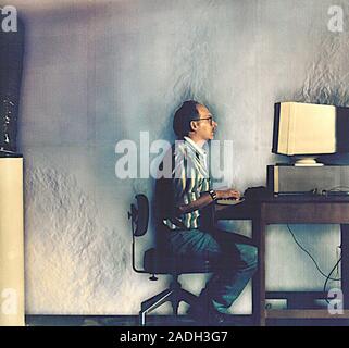 Office ventilation, Schlieren image. Air blown by a ventilation fan (lower left) and the heated air rising from the man and the computer monitor, are Stock Photo