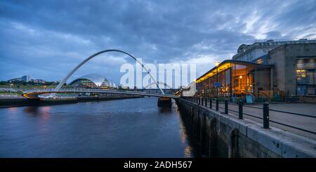 Newcastle and Gateshead quaysides at dusk, including the arch of the Millennium Bridge, the Sage and the Tyne Bridge, Tyne and Wear, England