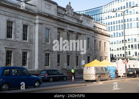 London, UK. 4th Dec, 2019. People continue to pay their respects on London Bridge five days after the terror attack by Usman Khan. People stand and look at the flowers, there is still a police presence and tents erected to preserve the crime scene. Credit: Keith Larby/Alamy Live News Stock Photo