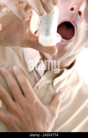 Asthmatic man using his inhaler during an asthma attack. Stock Photo