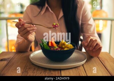 Small amount of salad on the fork in hand of woman Stock Photo