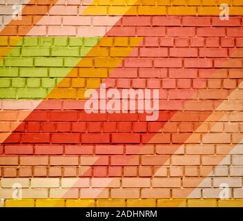 Brick wall texture with paint painted stylish street art design. Abstract multicolor urban graffiti. Stock Photo