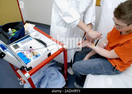 MODEL RELEASED. Sweat allergy test. Doctor using a probe to measure the pH of a patient's sweat. This is being carried out as part of a sweat allergy Stock Photo
