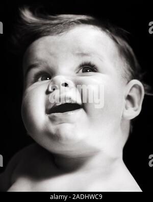 1940s 1950s SMILING BABY SHOWING TWO  FRONT TEETH HEAD TILTED LOOKING UP - b4514 HAR001 HARS SHOWING HEALTHINESS MALES SPIRITUALITY EXPRESSIONS B&W TEMPTATION HAPPINESS WELLNESS HEAD AND SHOULDERS CHEERFUL DISCOVERY STRENGTH EXCITEMENT POWERFUL DIRECTION AUTHORITY SMILES CONCEPTUAL ALERT CURIOUS JOYFUL STYLISH TILTED BABY BOY INTERESTED CREATIVITY GROWTH JUVENILES LOOKING UP BABY GIRL BLACK AND WHITE CAUCASIAN ETHNICITY EXPRESSIVE HAR001 OLD FASHIONED Stock Photo