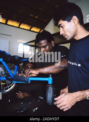 Wheelchair workshop. Technicians working in a wheelchair assembly workshop in Sri Lanka. They have been trained by the Motivation Charitable Trust, wh Stock Photo