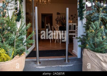 Berlin, Germany. 04th Dec, 2019. Two bollards stand in front of the entrance door of a café in Moabit. It triggered a debate on the Internet. Many Twitter users criticised the access as being hostile to children and disabled people and left bad ratings on several portals. Credit: Paul Zinken/dpa/Alamy Live News Stock Photo