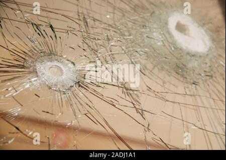 Two bullet holes in a pane of glass. The bullets were fired during a robbery at a travel agent's. Stock Photo