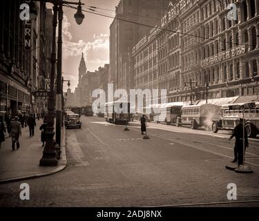 1930s LOOKING WEST MARKET STREET TO CITY HALL TROLLEY CARS TRAFFIC DEPARTMENT STORES  LIT BROTHERS BUILDINGS PHILADELPHIA PA USA - q41888 CPC001 HARS STORES TROLLEY REAL ESTATE STRUCTURES STYLISH EDIFICE BUSES LIT BROTHERS BLACK AND WHITE OLD FASHIONED Stock Photo