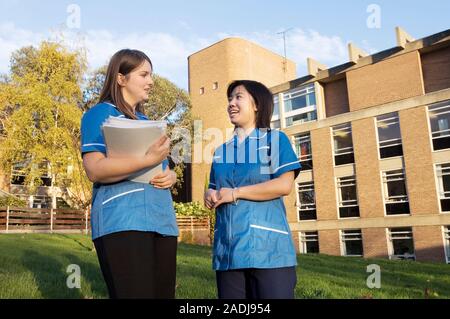 MODEL RELEASED. Nurses outside a hospital. Taking confidential medical records outside the hospital may be a breach of information security. Stock Photo