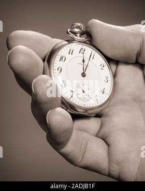 1960s MALE HAND HOLDING POCKET WATCH FOUR MINUTES PAST NOON OR MIDNIGHT - s16448 HAR001 HARS PRECISION BLACK AND WHITE CAUCASIAN ETHNICITY HAR001 KEEPING TIME OLD FASHIONED REPRESENTATION TIMEPIECE Stock Photo