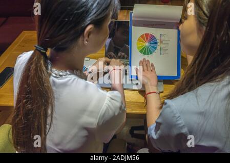 Rear view of office women discuss about financial document Stock Photo