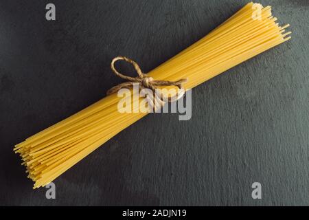Neat bunch of raw spaghetti tied with rope Stock Photo