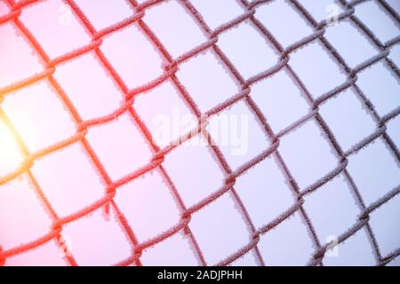 Mesh netting is covered with frost after heavy fog and frost with Sunny highlights. Stock Photo