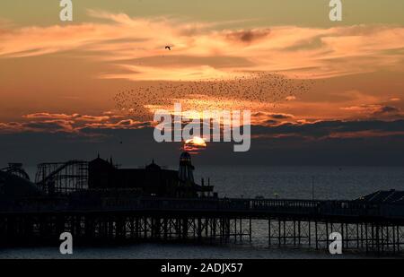 Brighton UK 4th December 2019 - The sun sets behind the helter skelter on Brighton Palace Pier after another beautiful sunny day on the south coast. Credit: Simon Dack / Alamy Live News Stock Photo