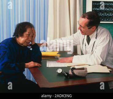Consultation for depression. General practice (GP) doctor comforts a depressed elderly woman. She may be feeling lonely, sad or hopeless. Feelings of Stock Photo