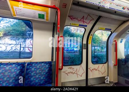 Graffiti inside a London Underground tube train carriage. Subway railway train with graffiti tag, tags. Handstyle tagging on doors of carriage Stock Photo