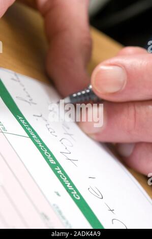 MODEL RELEASED. Specimen envelope being filled out by a doctor. This is used for sending samples to a laboratory for analysis. Stock Photo