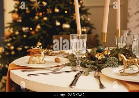 Table with candles served for Christmas dinner in living room, close up view Stock Photo