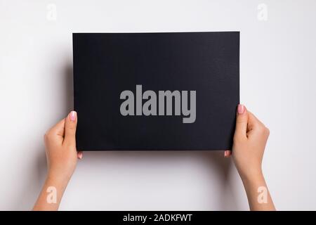 Female hands holding empty black paper Stock Photo