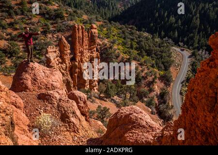 Hiker taking selfie with cell phone standing dangerously close to the edge of a cliff in red rock canyon of Southern Utah. Stock Photo
