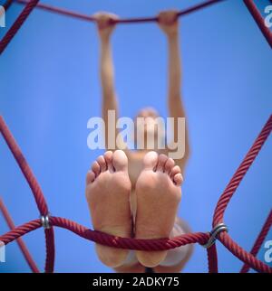 Woman climbing on a rope climbing frame. Stock Photo