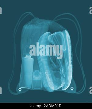 Sports bag. Coloured X-ray of a sports bag containing trainers, deodorant, shower gel and a towel. Stock Photo