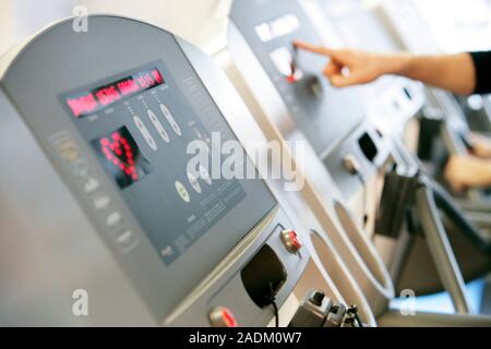 MODEL RELEASED. Running machines. Control panel display on a running machine in a gymnasium. The controls on these running machines can be used to adj Stock Photo