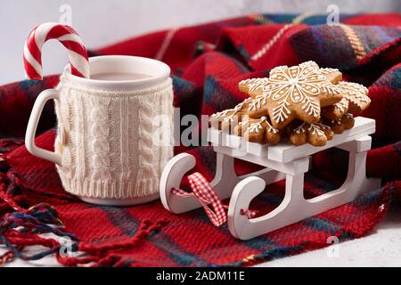 Christmas hot chocolate with candy cane and gingerbread cookies on wool plaid blanket, holiday concept Stock Photo