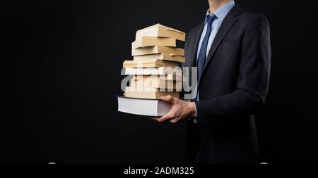 Man in Black suit with books in his hands Stock Photo