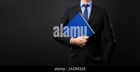 Man in black suit with book in his hand - No Face Stock Photo