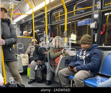 People riding a city bus after work in the evening in Brooklyn, New York. Stock Photo