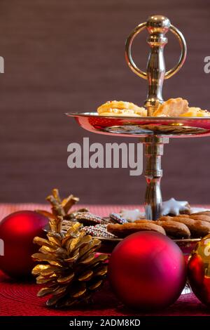 Decoration shelf on dining table. Red baubles with simple Brown Background. Biscuit and Sweets arrangement. Copy space for text Stock Photo