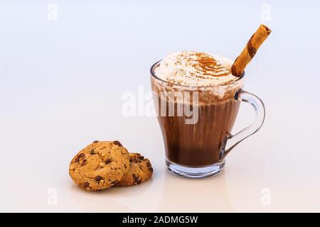 Hot chocolate with whipped cream, cinnamon, anise,  biscuits and sweet wafer roll stick. Stock Photo