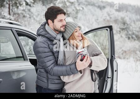 Looking at the outstanding landsape. Nice couple have weekend at countryside at winter time Stock Photo