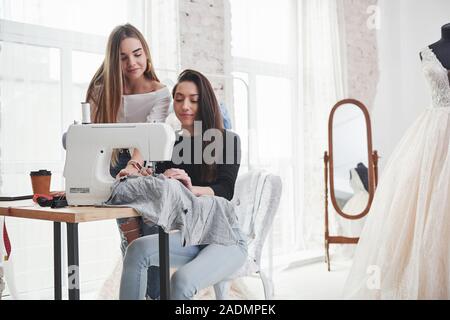Calm mood. Two female fashion designers works on the new clothes in the workshop Stock Photo