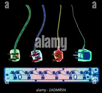 Electrical plugs and socket extension. Coloured X- ray of four 3-pin electrical plugs and a socket extension board. The plugs connect domestic applian Stock Photo