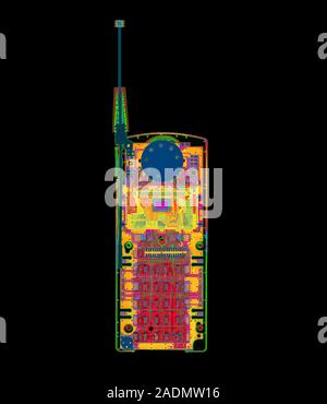 Mobile phone. Coloured X-ray of a mobile phone showing various components such as the circuit boards (red, lower frame), the earpiece (dark green at u Stock Photo