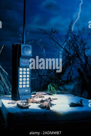Early mobile phone. Conceptual image of an NEC 'Brick' mobile phone used in the mid to late 1980s placed on a grave. This could represent this type of Stock Photo
