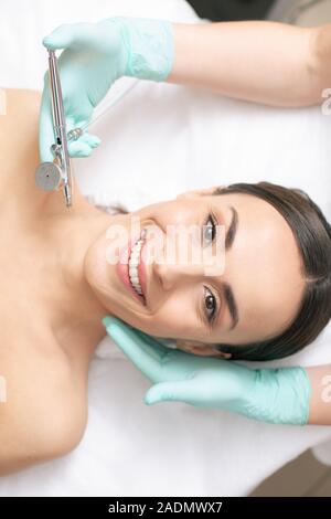 Confident woman smiling at the oxygen spray treatment Stock Photo