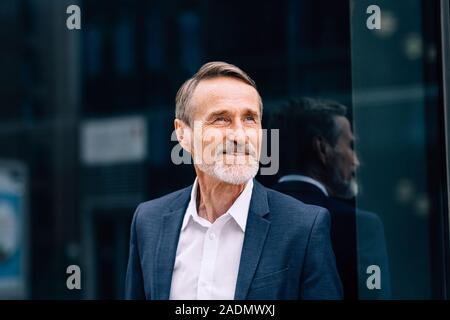 Bearded man wearing suit standing at office building outdoors Stock Photo