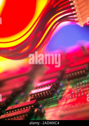 Circuit board. Printed circuit board with mounted microchips (processors, lower centre). Also seen is a connecting cable made up of insulated electron Stock Photo